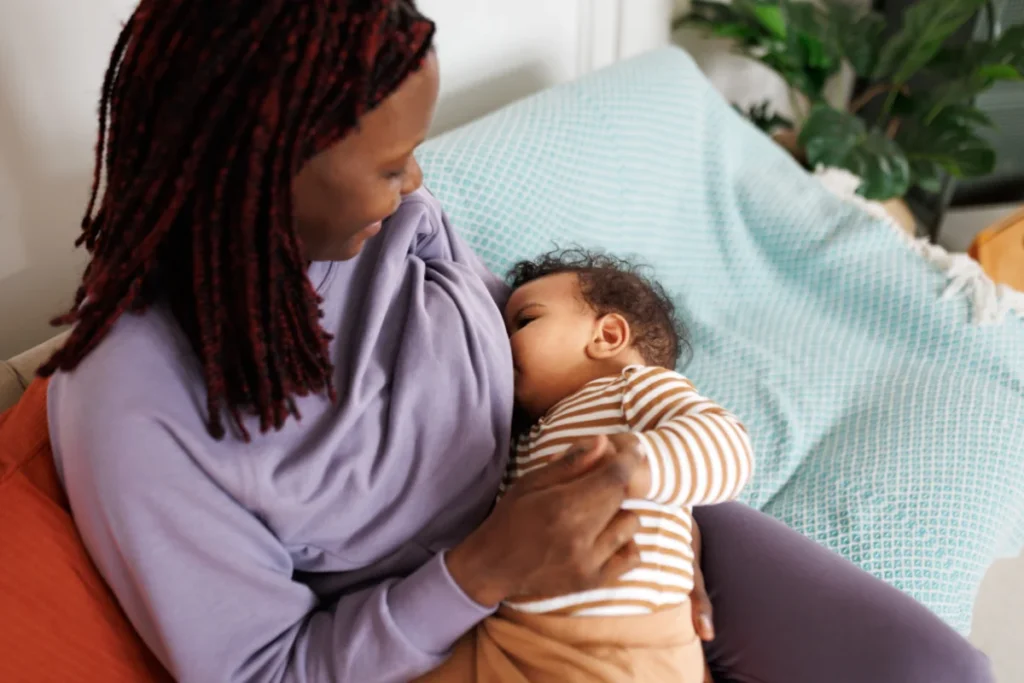 Bebê mamando no seio da mãe em amamentação livre demanda